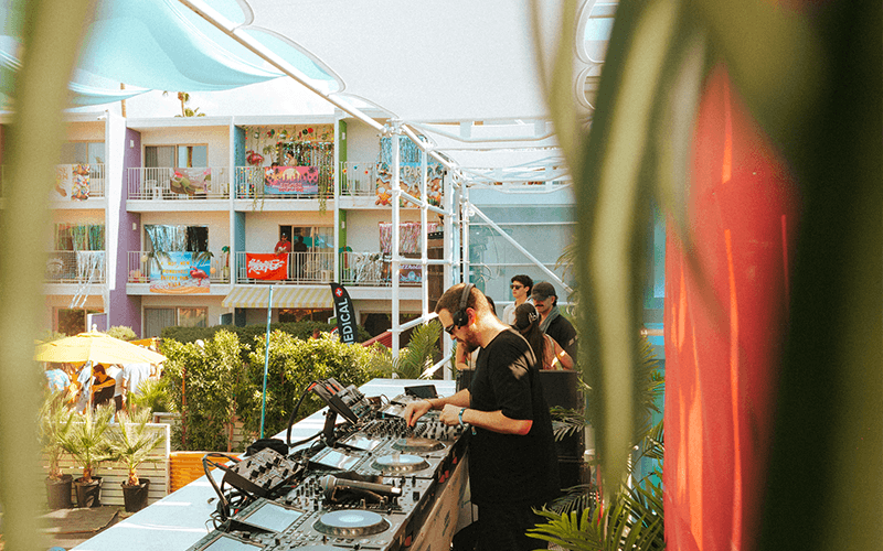 DJ performing beside a Palm Springs resort pool during Splash House.